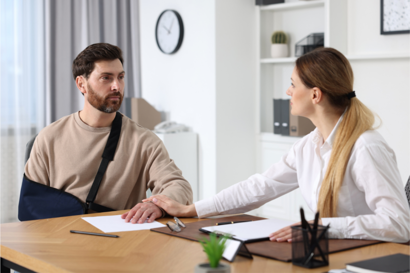 Injured man meeting with a professional and discussing paperwork.
