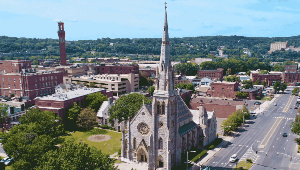 Aerial view of a city neighborhood featuring a large church and surrounding buildings.