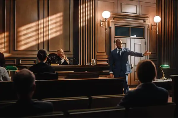 Attorney presenting a case in a courtroom before a judge and jury