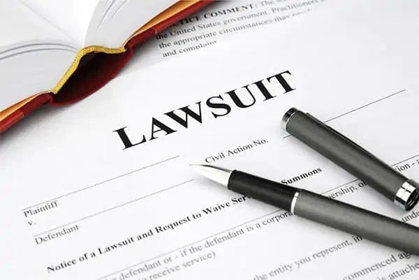 Lawsuit document with pen and law book on a desk