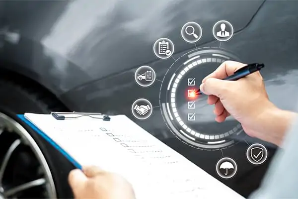 Person marking damages checklist on a car inspection report