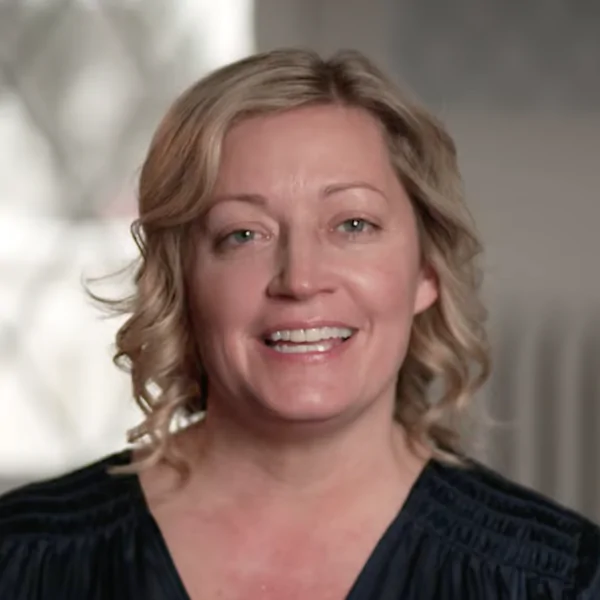 Portrait of a woman with short blonde hair giving a testimonial