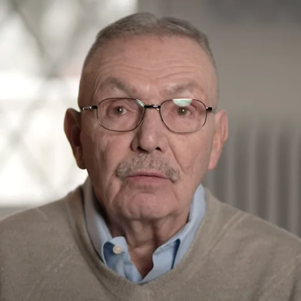 Portrait of an older man with glasses giving a testimonial