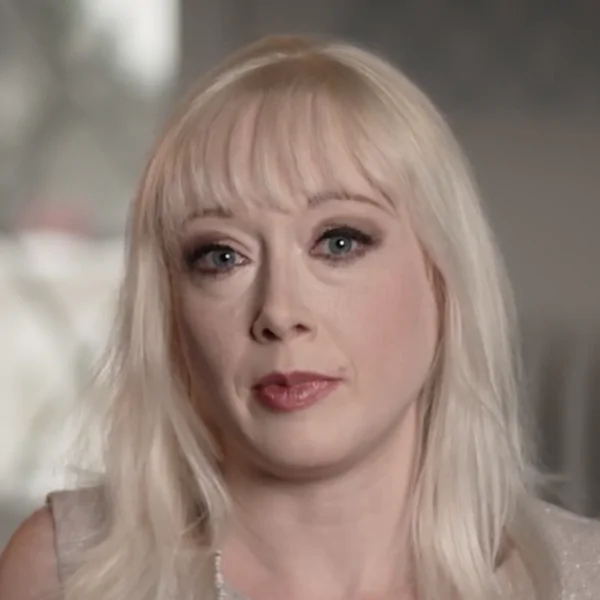 Portrait of a woman with platinum blonde hair giving a testimonial