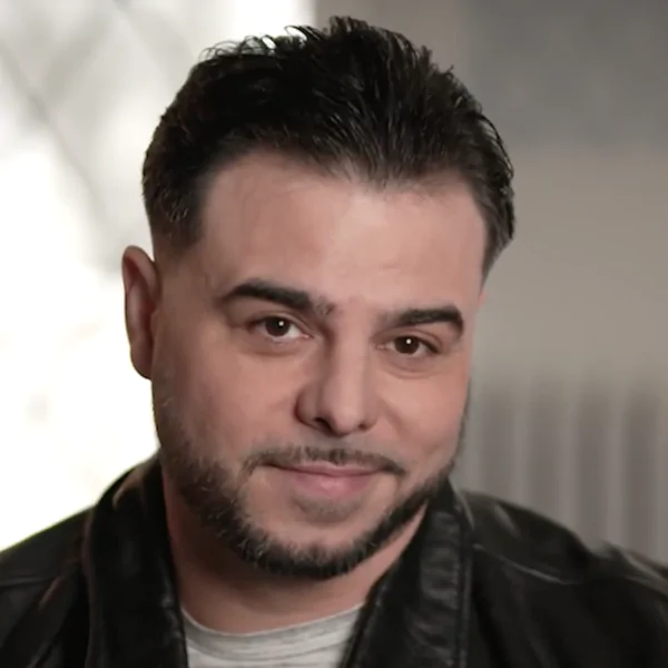Portrait of a man with short dark hair and beard giving a testimonial